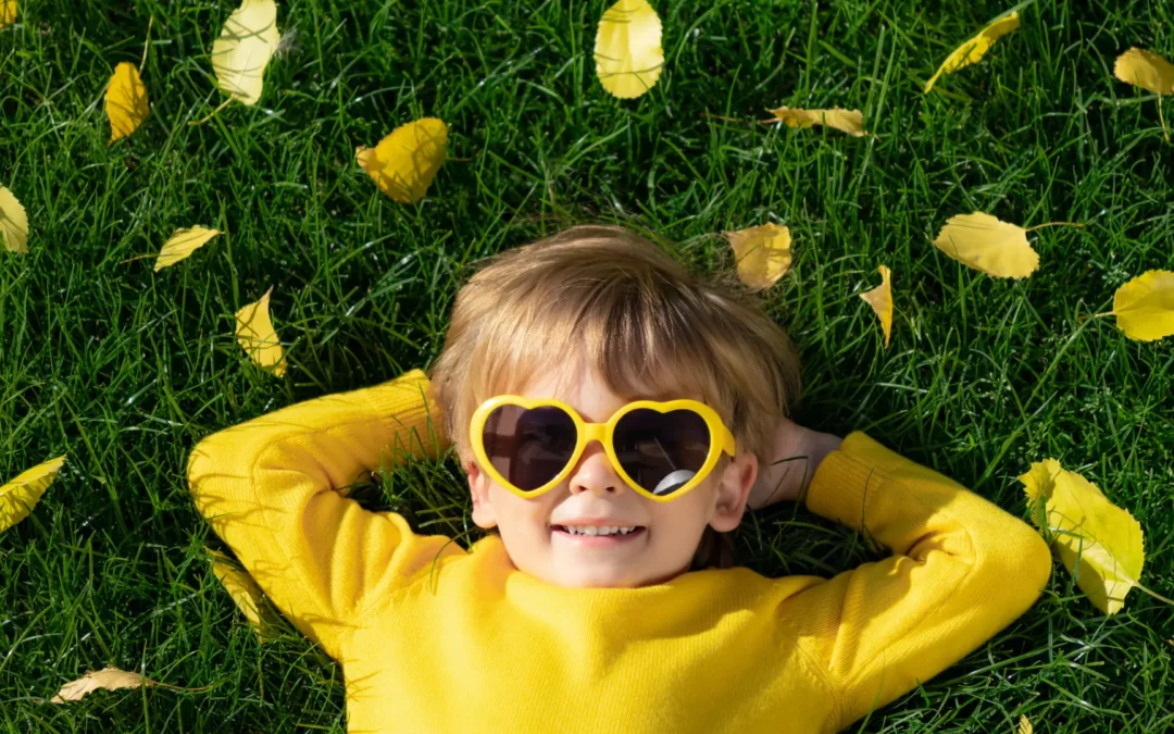 Enfant allongé sur l'herbe qui sourit, et si le bonheur s'apprenait